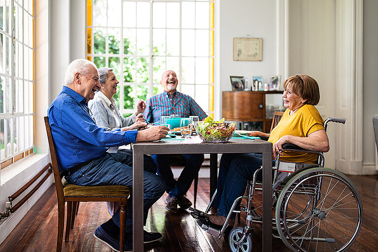 Ältere Leute lachen am Tisch
