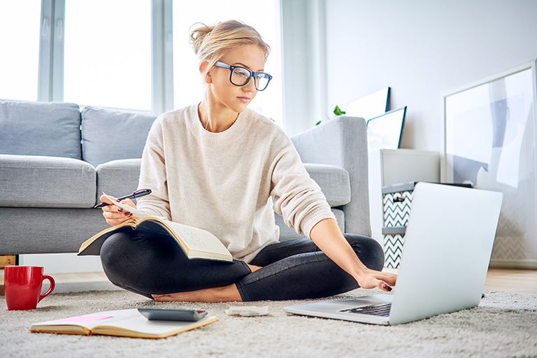 Junge Frau schaut in einen Laptop